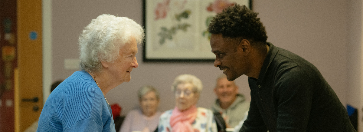 Two people sitting together in quiet conversation, reflecting human connection and understanding in a divided world.