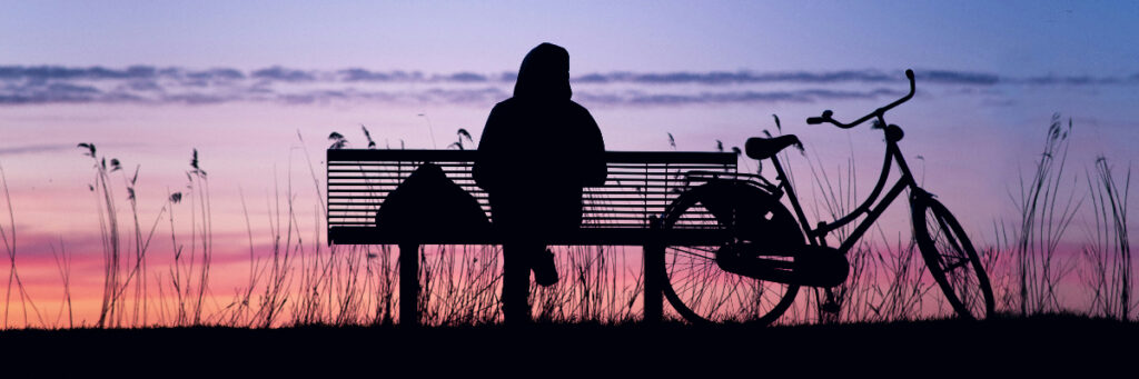 A person sitting quietly in soft evening light, reflecting and resting after an emotionally overwhelming day.