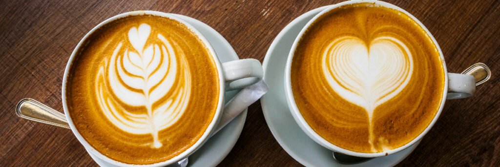 Two people sharing coffee and conversation at a café table.